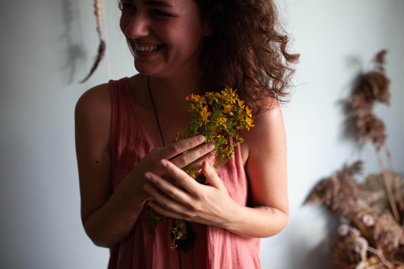 Jowita, jedna z autorek Blogrodu, uśmiecha się, trzymając w dłoniach bukiet dziurawca.
